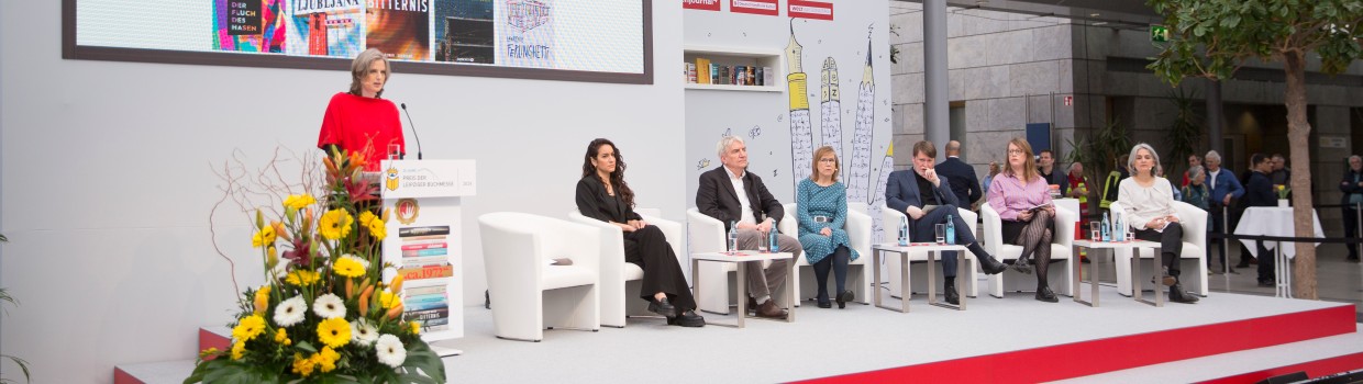 Blick auf die Bühne mit der Jury bei der Verleihung vom Preis der Leipziger Buchmesse 2024 in der Glashalle der Leipziger Messe